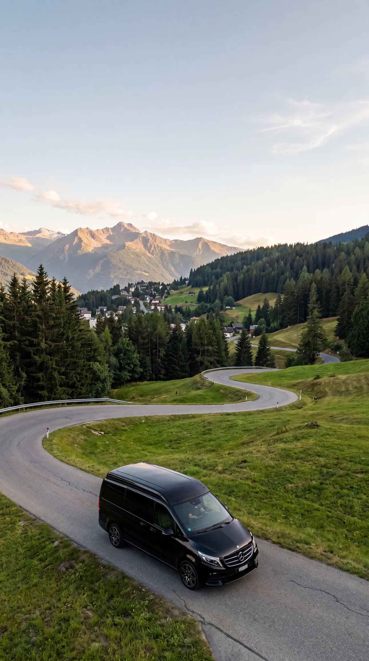 Taxi van Mercedes noir sur une route de montagne sinueuse à Crans-Montana en été